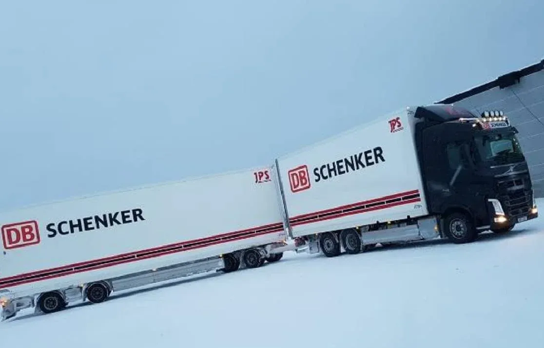 Volvo med skåp uppställd på snötäckt plan.